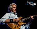 Ein älterer Mann spielt eine E-Gitarre auf einer Bühne vor dunklem Hintergrund. Oben rechts steht 'Jazz Nights'.