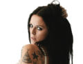 Eine Frau mit langen dunklen Haaren und mehreren Tattoos blickt über die Schulter, während sie ihr Haar hält. Hintergrund ist weiß.