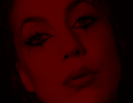 Porträt einer Person mit dramatischem Make-up und von rotem Licht beleuchtet, Ausdruck melancholisch.