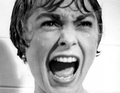 Eine Frau schreit in Panik, nasses Haar, offener Mund, Augen weit geöffnet, schwarz-weiß Foto.