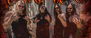 Vier Männer in schwarzen Shirts, posieren mit Rocker-Handgesture vor einer verfallenen Gebäude-Kulisse.