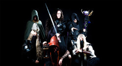Eine Gruppe von sechs Personen in Fantasy-Kleidung und Rüstungen posiert dramatisch mit Waffen auf schwarzem Hintergrund.