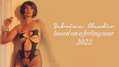 Eine Person in einem schwarzen, ausgeschnittenen Outfit lehnt an einer Wand. Text: 'Sabrina Claudio, based on a feeling tour 2022'.