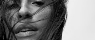 Nahaufnahme eines Gesichts einer Person mit wehendem Haar im Wind, in Schwarz-Weiß gehalten.